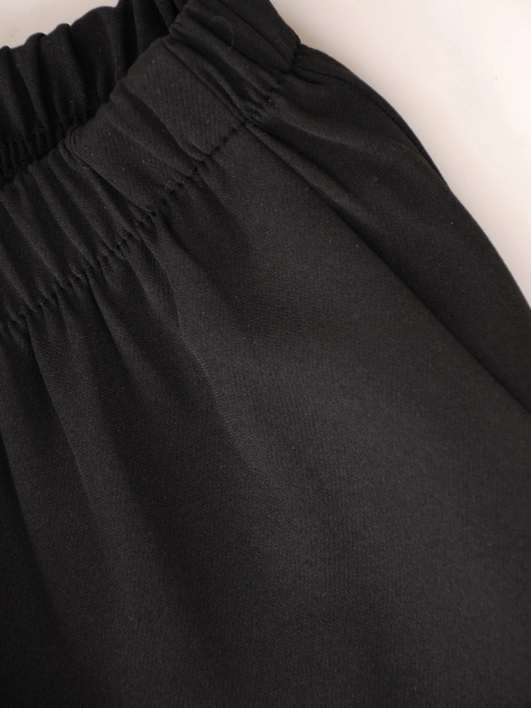 Elegancki kostium damski z szerokimi spodniami – tuszujący fason z ozdobną broszką 37467