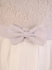 Elegancka biała sukienka rozkloszowana midi – fason z kokardą pięknie modelujący sylwetkę 33069