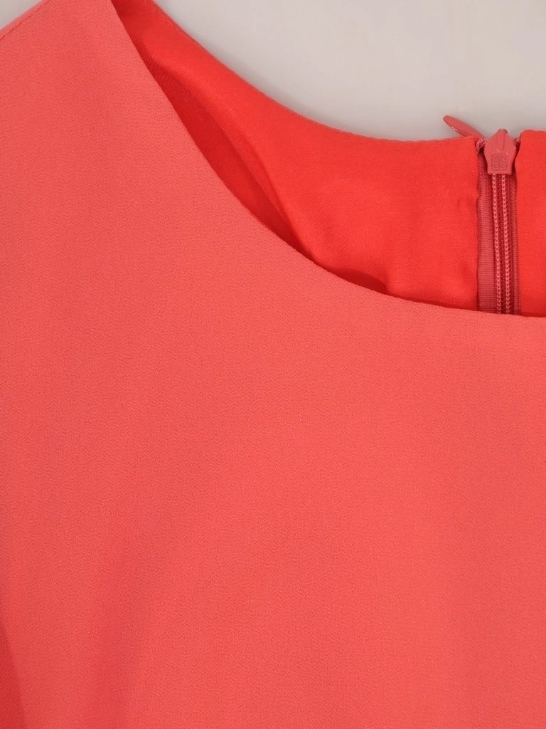 Wizytowa sukienka trapezowa koralowa na przyjęcia – tuszujący sylwetkę krój z falbanami 28974